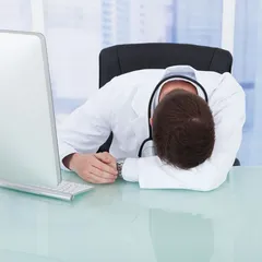 Tired Male Doctor Resting At Desk