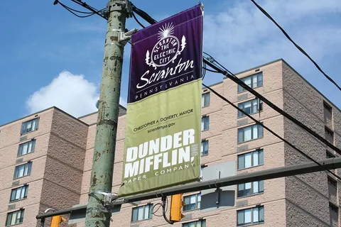 A banner promoting Dunder Mifflin, the fictional paper company on NBC's "The Office" hangs in downtown Scranton