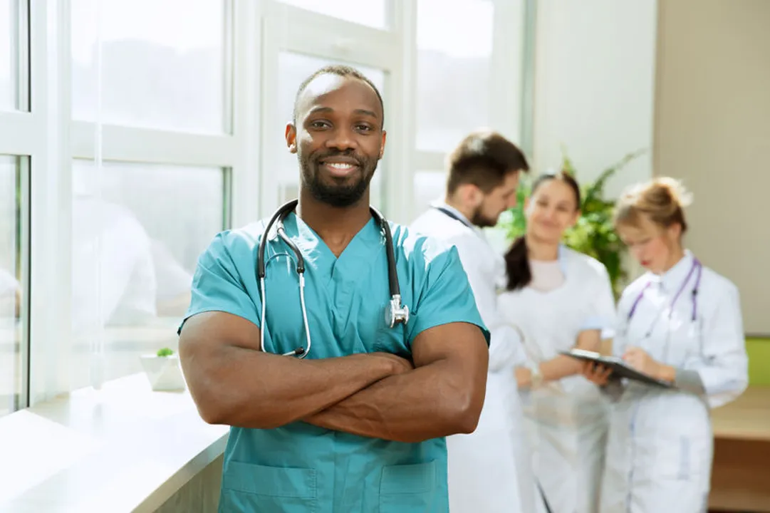 A young male nurse is smiling on the job