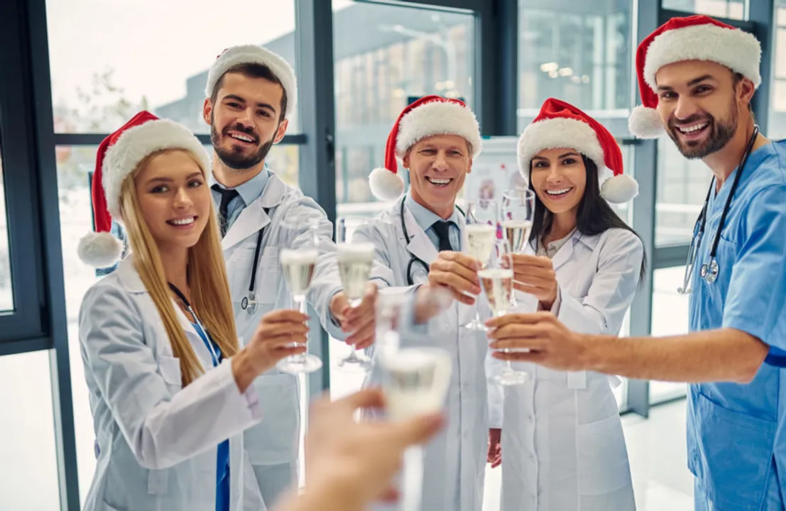 Doctors in santa hats clink champagne