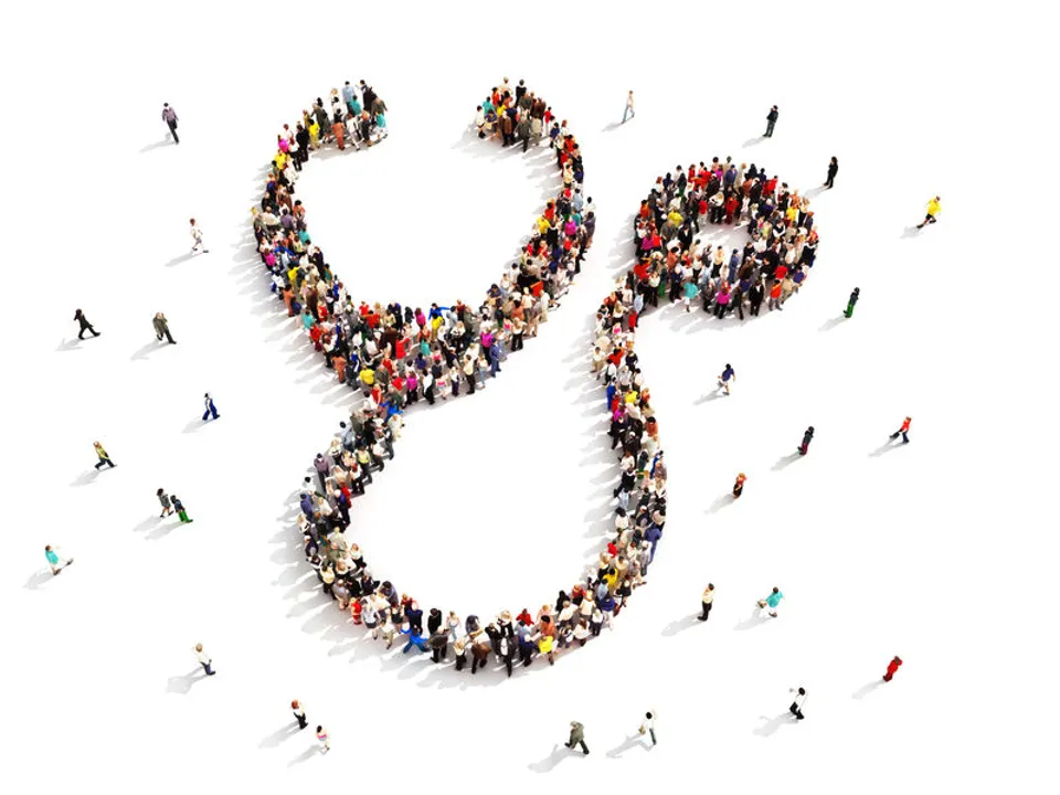 A large group of physicians forms together in the shape of a stethoscope