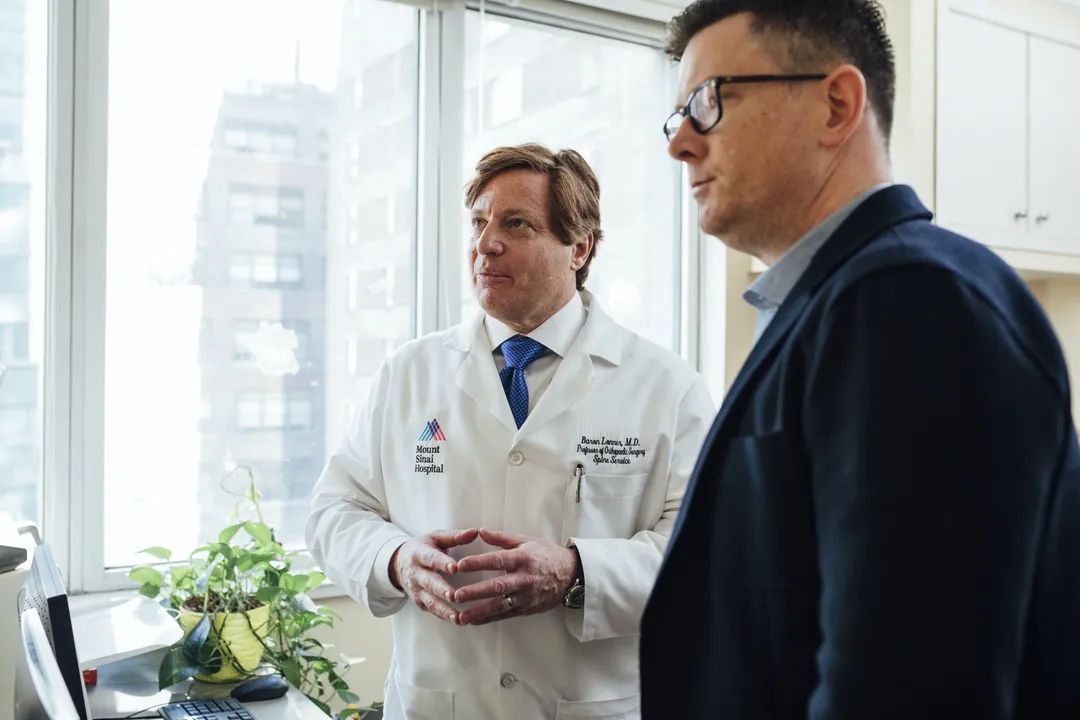 A doctor in a labcoat standing nearby a patient