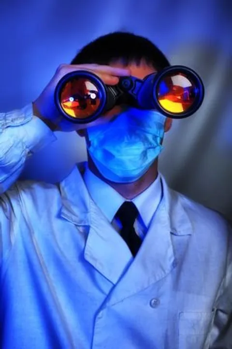 Physician searching for a job using binoculars