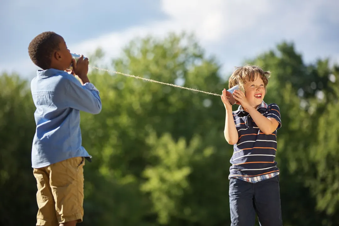 Kids play "telephone" symbolizing communication problems that can occur during a job search or hiring effort