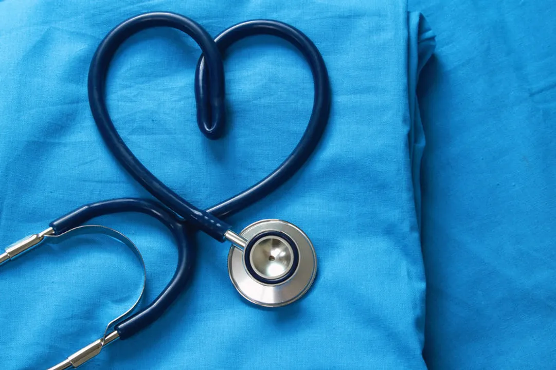 A picture of a stethoscope and scrubs. The stethoscope is twisted into the shape of a heart.