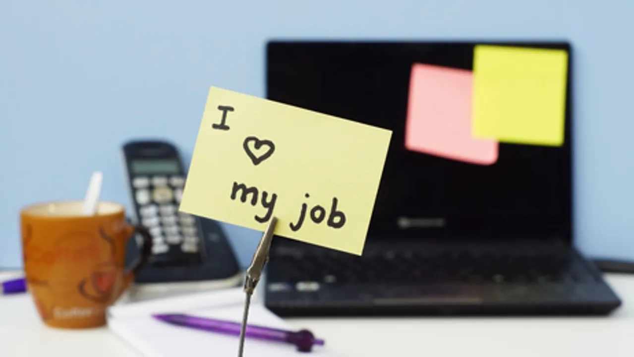 Physician with "I love my job" note on desk