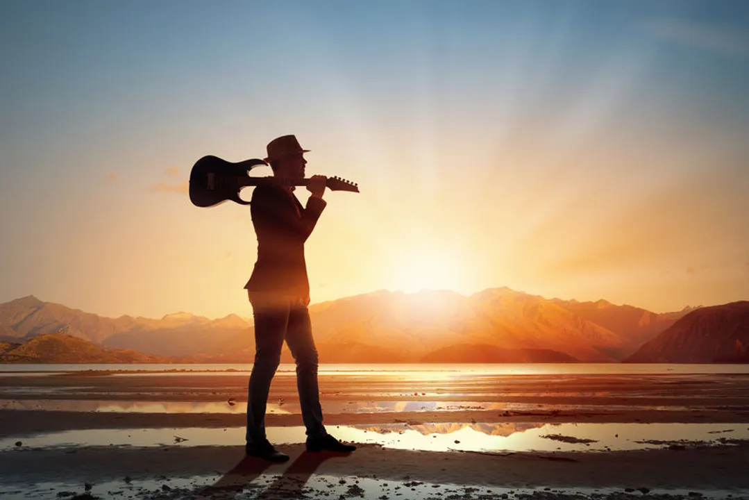 A physician "rock star" takes a stroll on the beach with his guitar. The article discusses what is meant by the term "rock star" when it is applied to physicians and how doctors can become that type of physician