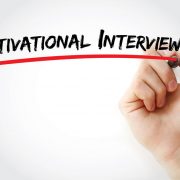 A hand and marker write the text, "motivational interviewing." The article discusses how concepts of motivational interviewing can be incorporated and can benefit physician recruitment